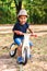 Afro-american or latin boy rides on wooden bicycle in park