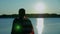 Afro-american man with American flag on shoulders looks into distance at sunrise