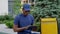 Afro-american man courier delivery sitting on bench with backpack uses tablet