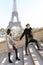 Afro american man and european girl walking on stairs, Eiffel Tower in background, Paris.