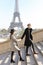 Afro american man and girl holding hands and walking on stairs, Eiffel Tower in background, Paris.