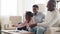 Afro american mixed race ethnic family african parents and little daughter toddler child sitting at home sofa schoolgirl