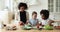 Afro american mother teaching cooking little multiracial girls children.