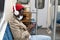 Afro-American passenger man sitting in subway train, wear face medical mask to protect yourself from flu virus, covid-19, using