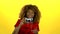 Afro american photographer holds a camera in her hands . Yellow background. Slow motion