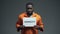 Afro-american prisoner holding Amnesty sign, asking for help, human rights