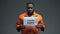 Afro-american prisoner holding Human rights sign, ill treatment, awareness