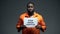 Afro-american prisoner holding stop prison corruption sign, faulty system