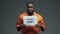 Afro-american prisoner holding Where is law sign in cell, wrongly accused person