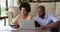 Afro American spouses calculate bills by laptop at home office