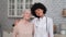 Afro american woman doctor and patient senior woman standing and smiling at home