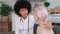 Afro american woman doctor wishes well for a senior woman putting her hand on her shoulder