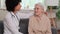 Afro american woman doctor wishes well for a senior woman putting her hand on her shoulder