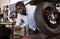 Afro american worker inspects the wheel of a motorcycle