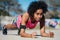 Afro athletic woman doing pushups outdoors.