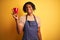 Afro barista man with dreadlocks drinking cup of coffee over isolated yellow background with a happy face standing and smiling