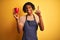 Afro barista man with dreadlocks drinking cup of coffee over isolated yellow background surprised with an idea or question