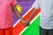 Afro Boy and girl joined hands on background flag of Namibia