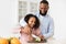 Afro father teaching daughter how to prepare salad