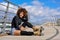 Afro hairstyle woman on roller skates sitting on urban bridge