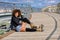 Afro hairstyle woman on roller skates sitting on urban bridge