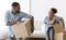 Afro Spouses Carrying Moving Boxes And Laughing Entering New House