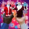 Afroamerican and caucasian-white hands holding phones with 2 Santa Clauses.