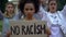 Afroamerican girl holding No racism sign, activists chanting Human rights slogan