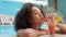 Afroamerican lady on journey summer vacation bathing in Maldives hotel pool drink luxury juice cocktail flirts smiling