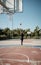 Afroamerican young man playing street basketball in the park