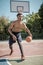 Afroamerican young man playing street basketball in the park