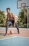 Afroamerican young man playing street basketball in the park