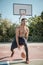 Afroamerican young man playing street basketball in the park