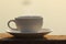 Afternoon coffee cup and book on wooden board with golden light