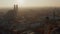 Afternoon Sun peeking through Cityscape of Munich with Frauenkirche Cathedral Silhouette on a Winter Day, Aerial slow