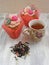 Afternoon tea with roses cupcakes in vintage teacup ans flowers brew on shabby table colors of spring