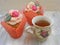 Afternoon tea with roses cupcakes in vintage teacup on shabby table colors of spring