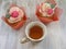Afternoon tea with roses cupcakes in vintage teacup on shabby table flat wiev