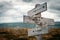 Against all odds text on wooden rustic signpost outdoors in nature/mountain scenery.