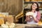 Against the backdrop of the bread shelves, a young attractive saleswoman shows a round cross-section of wheat bread