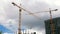 Against the backdrop of a cloudy sky on a sunny summer day, the work of a construction crane crossing the cargo.