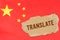 Against the background of the Chinese flag lies cardboard with the inscription - Translate