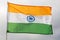 Against background of cloudy sky, tricolour Indian flag flutters on flagpole