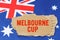 Against the background of the flag of Australia lies cardboard with the inscription - Melbourne Cup