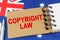 Against the background of the flag of Australia lies a notebook with the inscription - COPYRIGHT LAW