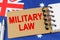 Against the background of the flag of Australia lies a notebook with the inscription - MILITARY LAW