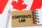 Against the background of the flag of Canada lies a notebook with the inscription - CORPORATE LAW