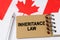 Against the background of the flag of Canada lies a notebook with the inscription - INHERITANCE LAW