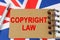 Against the background of the flag of Great Britain lies a notebook with the inscription - COPYRIGHT LAW