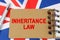 Against the background of the flag of Great Britain lies a notebook with the inscription - INHERITANCE LAW
